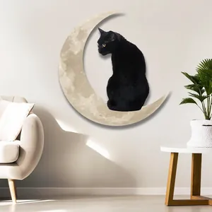 Black cat sitting on a crescent moon metal wall art decor in a minimalist living room