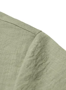 Macro view of light green linen shirt fabric texture and shoulder stitching detail