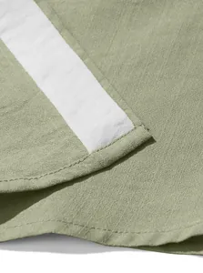 Close-up of sage green casual shirt fabric showing breathable texture and stitching