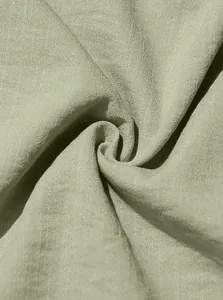Macro view showing the breathable light green linen fabric texture of a men's shirt