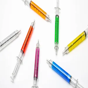 Detail view of creative colorful syringe shaped ballpoint pens on white background