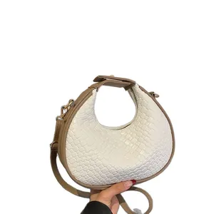 Elegant white woven crescent shoulder bag with khaki strap and gold-tone accents