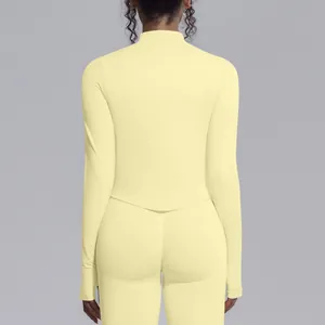 Detailed back view of women's seamless pale yellow mock neck yoga top and tight leggings