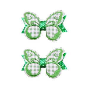 Vue détaillée macro de la broderie verte et des paillettes sur les barrettes papillon