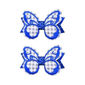 Vue détaillée de pinces à cheveux papillon pailletées bleues avec broderie et carreaux