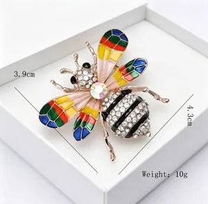 Vue détaillée d'une broche abeille en strass colorés dans un coffret cadeau