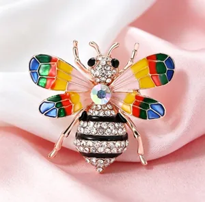 Vue détaillée d'une broche abeille en alliage avec des ailes en émail et des strass.