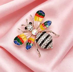 Détail d'une broche abeille en alliage avec ailes en émail et strass brillants