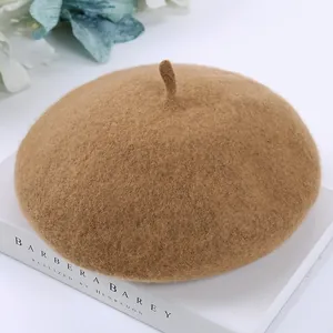 Close-up detail view of a vintage camel wool beret hat showcasing its soft textured fabric