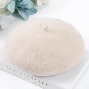 Detailed macro view of a soft beige wool beret hat placed on a decorative white book