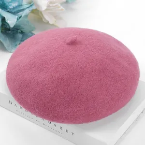 Macro detail view of a pink wool beret with soft knitted texture on a white book