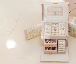 Detailed view of a pink three-layer jewelry box with mirror and pull-out drawers.