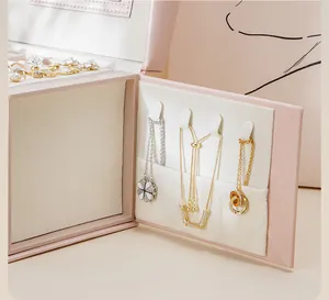 Detail shot of pink jewelry box interior with hooks for necklaces and plush lining.
