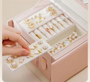 Detailed view of pink three-layer jewelry storage box with drawers and earring compartments