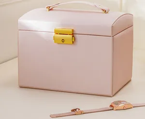 Elegant pink faux leather jewelry box featuring a stylish gold lock and sturdy handle.