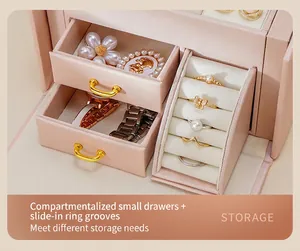 Macro view of pink three-layer jewelry box showing divided drawers and velvet ring slots