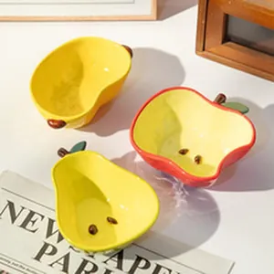Detail view of cute fruit-shaped ceramic bowls in vibrant apple and pear designs