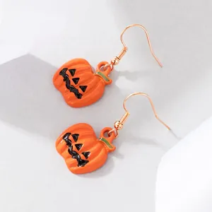 Detailopname van Halloween pompoen oorbellen met een levendige oranje emaille laag.