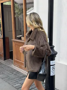 Detailed side view of a stylish woman wearing a brown faux fur coat and black leather skirt