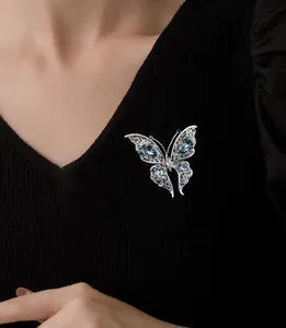 Detailed view of an elegant blue crystal butterfly brooch pinned on a black sweater