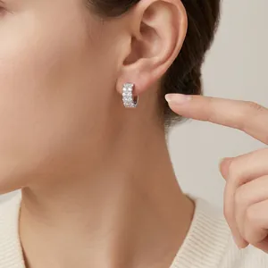 Close-up of 925 sterling silver moissanite hoop earrings being worn on a woman's ear