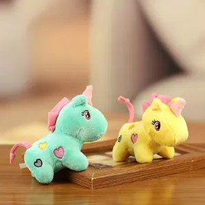 Paire de breloques licornes en peluche vert menthe et jaune avec broderie de cœur.