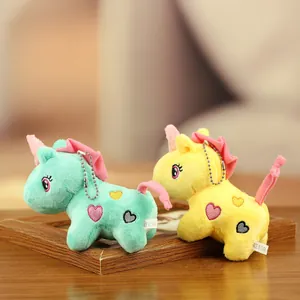 Gros plan de mignons porte-clés licorne en peluche vert et jaune.