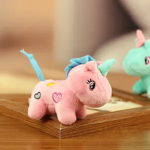 Détail d'un porte-clés licorne en peluche rose douce avec broderie cœur et crinière bleue.