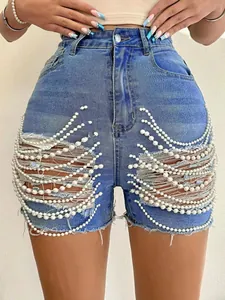 Détail de short en jean taille haute avec une chaîne de perles élégante et des déchirures.