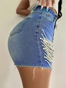 Vue de côté d'un short en jean taille haute avec chaînes de perles et détail déchiré