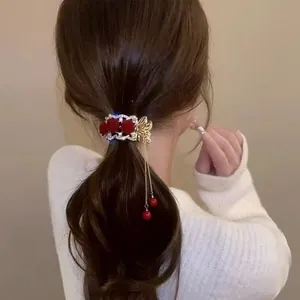 Pince à cheveux élégante avec roses rouges et pompons dorés pour coiffure queue de cheval