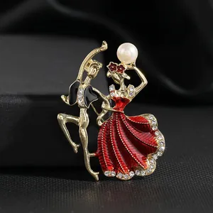 Elégante broche couple de danseurs de ballet dorée avec émail rouge et cristaux brillants.