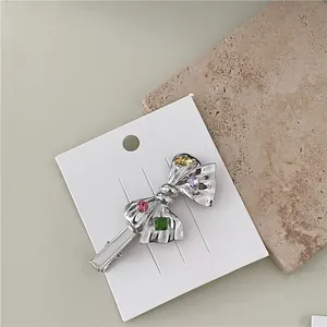 Elegant Korean silver bow hair clip featuring colorful crystal rhinestones on a white card