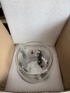 Close-up top view of a double-walled Christmas themed glass mug inside foam packaging box