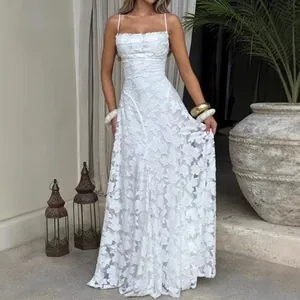 Robe longue blanche sans manches en dentelle avec broderie florale et taille cintrée.