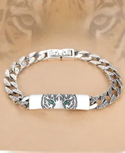 Detailed close-up of S925 sterling silver tiger bracelet featuring green stone eyes and carving.