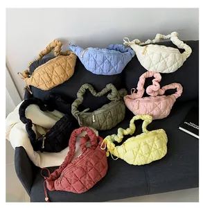 Assorted colorful quilted puffer cloud bags with ruffled straps displayed on a sofa