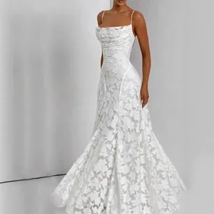 Robe longue élégante en dentelle blanche sans manches avec une taille cintrée chic.