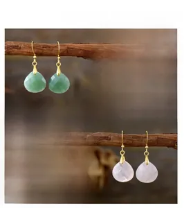 Close-up detail of teardrop natural stone earrings in green and pink stone options