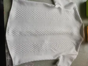 Detailed texture of white jacquard knitted men's polo shirt with diamond patterns
