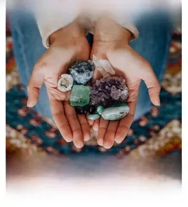 Various raw natural crystals and gemstones held in hands showing natural textures