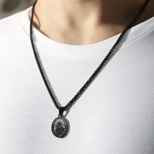 Close-up view of a black stainless steel Saint Joseph religious medal pendant necklace