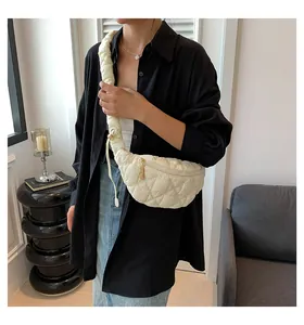 Detail view of a white quilted puffer cloud crossbody bag with drawstring strap.