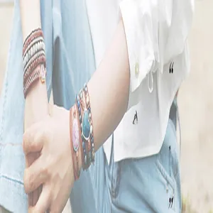 Close-up of layered handmade wrap bracelets featuring natural stones and beads.