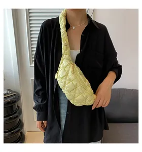 Stylish yellow quilted puffer chest bag with adjustable drawstring strap shown on model