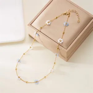 Elegant Korean style necklace with white and blue pearl flowers on a gold chain