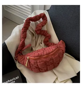 Detailed macro view of red quilted cloud bag with unique ruffled shoulder strap and gold zipper