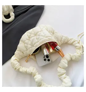 Detail view showing internal capacity of the white quilted cloud bag with cosmetics