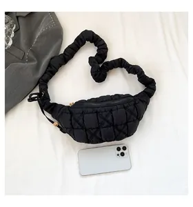 Detailed view of a black quilted puffer chest bag with a ruffled scrunchie strap