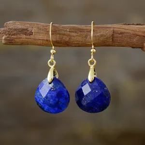 Elegant lapis lazuli teardrop earrings with gold hooks on a natural branch